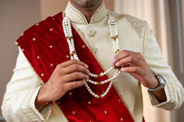 Indian groom in Sherwani with gold and pearly necklace - obrazy, fototapety, plakaty