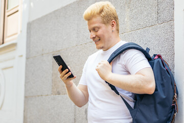 Young albino man using smartphone in the city