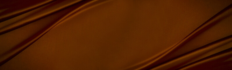 Black dark chocolate brown orange gold elegant luxury background. Silk satin velvet fabric. Fold ...