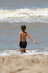 boy on his back entering the water in the sea. Beach on vacation