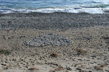 海岸の散歩中に面白い石積みを見つけた。誰が作ったのか、大きなハート形をしている。好きな人にプレゼントしたのかな。それとも海の彼方の外国に愛する人がいるのかな。あるいは海で命を失った大切な人を忍んで作られたのか。深い愛情が込められている美しい造形。