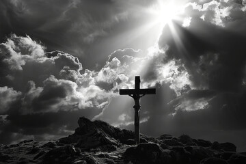Silhouette of crucifix against dramatic cloudy sky with beams of sunlight. Sun rays breaking through the clouds