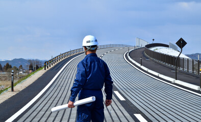 完成した道路をチェック点検する現場監督