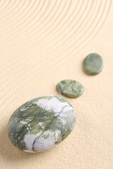 Fototapeta na wymiar Zen garden stones on beige sand with pattern