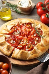 Tasty galette with tomato, rosemary and cheese (Caprese galette) on wooden table, closeup