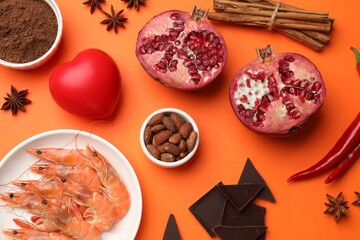 Natural aphrodisiac. Different products and heart model on orange background, flat lay