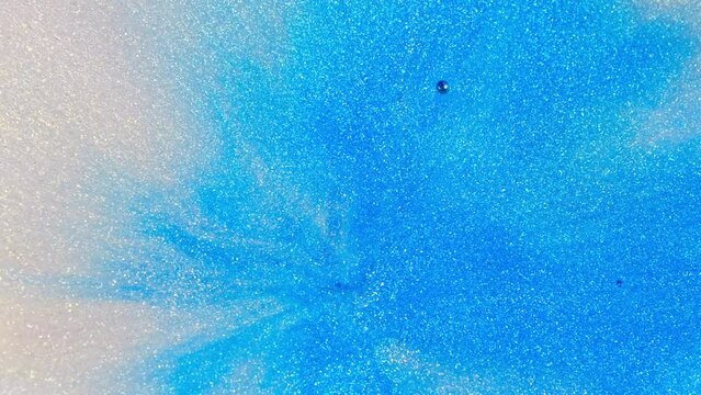 Vibrant blue ink expanding in clear water, creating an abstract diffusion pattern, high-angle shot