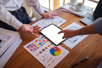 Creative designer or developer team using digital tablet working together on mobile app wireframe design at office.