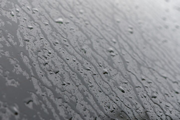 Full frame of the water droplets sliding on a black wet surface.1