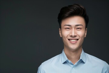 A man with a blue shirt and short hair is smiling