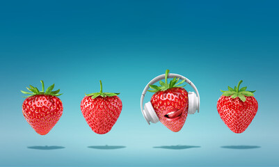 Summer minimalist pop art composition made with 4 strawberries wearing headphones and listening to music.Minimal concept summer and party.Celebrating the summer vibes.Creative art.Contemporary style.