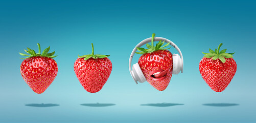 Summer minimalist pop art composition made with 4 strawberries wearing headphones and listening to music.Minimal concept summer and party.Celebrating the summer vibes.Creative art.Contemporary style.