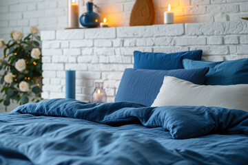 Cozy bedroom interior with blue bedding and decorative candles. Home comfort and design.