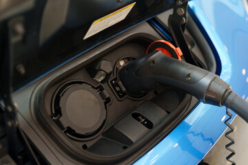 Close-up of an electric car being charged, illustrating the concept of eco-friendly fuel or...