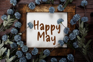 Happy May alphabet letters with flowers frame on wooden background