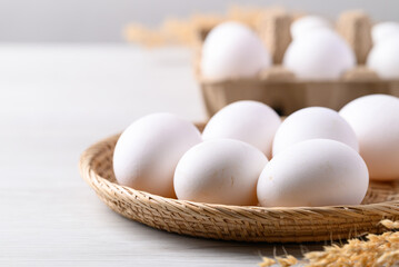 Organic white leghorn egg from free range farm in natural basket - obrazy, fototapety, plakaty