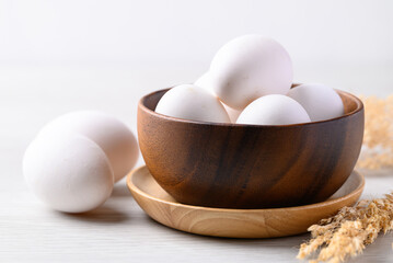 Organic white leghorn egg from free range farm in wooden bowl - obrazy, fototapety, plakaty