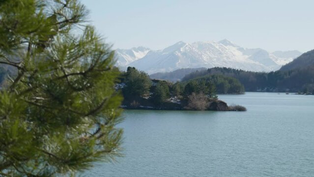 Snow covered mountain peaks background spring lake Aoos sunny day slow motion