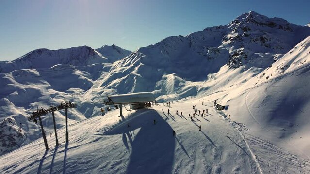 Sunny day at ski lift in white alpine mountains during winter sport season