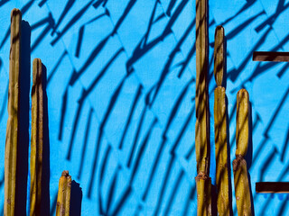 Background of blue wall with cacti and shadows of festive street decorations in Oaxaca Mexico. 
