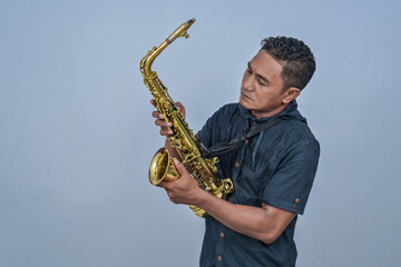 Naklejka premium A man holding a Saxophone