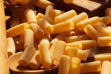 Pasta laying on the brown table with utensils