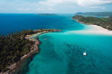 Boat floating on blue water at tropical island