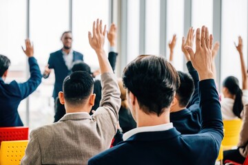 A meeting seminar and strategy session take place in the boardroom. Questions are posed and hands are raised demonstrating teamwork among colleagues and employees.