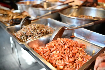 Market stalls sell crispy fried creek shrimps, a small freshwater delicacy known for its tender meat. This dish is deliciously crispy outside and tender inside, offering a delightful flavor.