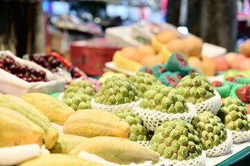 A fruit stand in Taiwan features a close-up of a custard apple, prized for its sweet flavor and nutritional value. Originally from the Americas, this tropical fruit has found popularity in Taiwan.