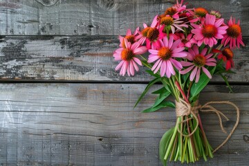 Rustic bouquet featuring Echinacea flowers tied with twine, against an aged wooden background.