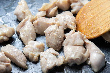 鶏もも肉をフライパンで炒める調理シーン。
