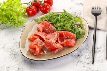 Sliced salmon with fresh arugula