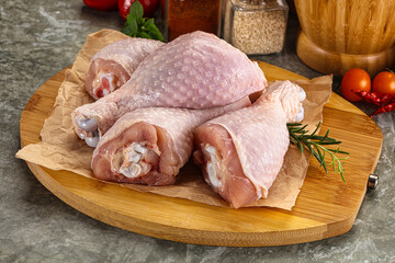 Raw uncooked chicken drumsticks over board