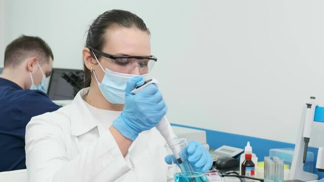 Female scientist using a micropipette for analysis in a modern laboratory. Advanced scientific laboratory of medicine and biotechnology development. Close-up