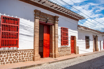 Colonial architecture with vibrant red doors and windows in Santa Fe de Antioquia, Colombia