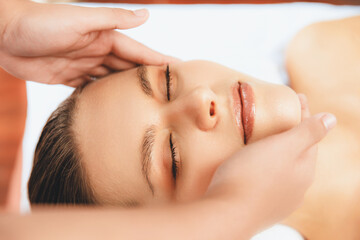 Closeup woman enjoying relaxing anti-stress head massage and pampering facial beauty skin...