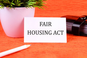 Business concept. Text fair housing act it is written on a white business card next to a business...