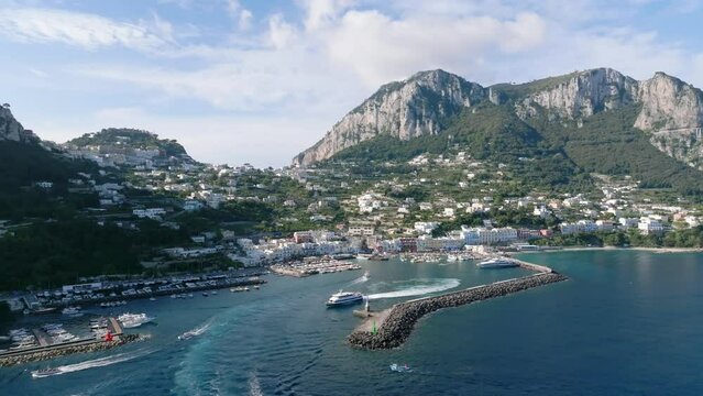 Traghetto esce dal porto dell'isola di Capri.Italia.
Ripresa aerea con drone di Marina Grande, meta turistica per viaggi di lusso in Italia.