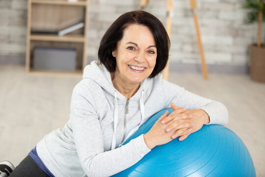 smiling fit aged lady with exercise ball