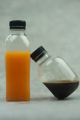Fresh orange juice in a plastic bottle and black coffee ready to mix