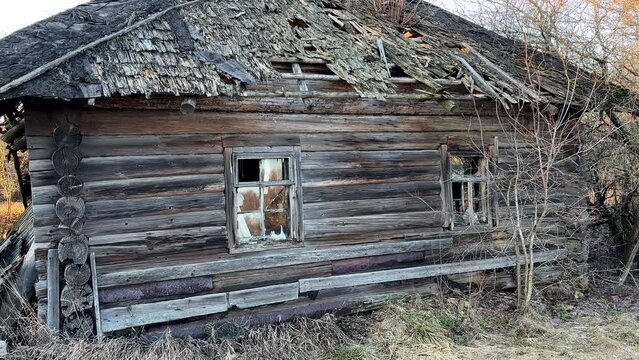 Abandoned house in village. Old wooden house in countryside in spring. No people in village. Old House in rural. Abandoned village with destroyed houses. Wooden Home ruin in countryside