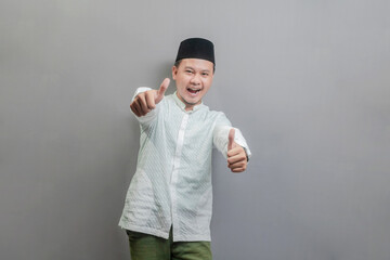 Happy asian muslim man thumbs up smiling and happy for success