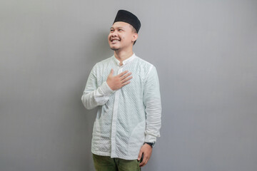 Asian Muslim man standing looking empty space happily to show grateful