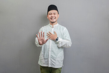 Asian muslim man doing stop sign with palm of the hand
