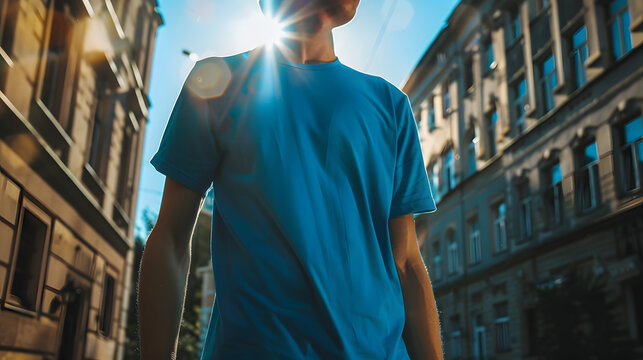 mockup showcasing a suave man with a  clad in a stylish blue t-shirt, confidently striding along a vibrant city street, radiating urban sophistication and modern allure amidst, no face