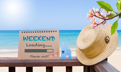 Weekend loading calendar on wooden fence with tropical beach background, tourism industry, greeting card idea