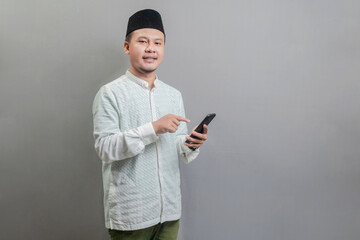 Happy asian muslim man using smart phone cellphone for calls