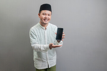 Happy asian muslim man showing smart phone cellphone for calls
