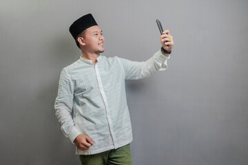 Happy asian muslim man using smart phone cellphone for calls